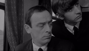 Movie still from “A Hard Day's Night” (1964), directed by Richard Lester – A black and white photo of a man in a suit; Close Up shot, High angle