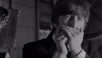 Movie still from “A Hard Day's Night” (1964), directed by Richard Lester – A man in a suit and tie holding his hands to his face; Close Up shot, Over the shoulder angle