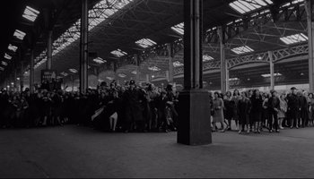Movie still from “A Hard Day's Night” (1964), directed by Richard Lester – A group of people standing in a train station; Extreme Wide shot, High angle