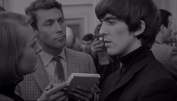 Movie still from “A Hard Day's Night” (1964), directed by Richard Lester – Two men are looking at a cell phone; Close Up shot, Over the shoulder angle