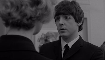 Movie still from “A Hard Day's Night” (1964), directed by Richard Lester – A man in a suit and tie talking to another man in a suit and tie; Close Up shot, Over the shoulder angle