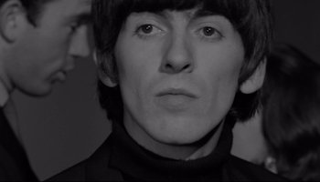 Movie still from “A Hard Day's Night” (1964), directed by Richard Lester – A black - and - white photo of a young man with long black hair; Close Up shot, High angle