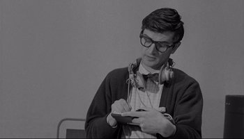 Movie still from “A Hard Day's Night” (1964), directed by Richard Lester – A young man wearing headphones writing on a notepad; Close Up shot, Low angle