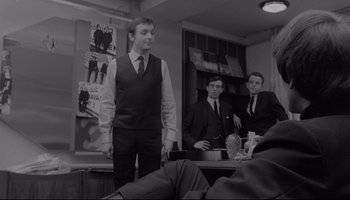 Movie still from “A Hard Day's Night” (1964), directed by Richard Lester – A group of young men in suits and ties in a room; Medium shot, Low angle