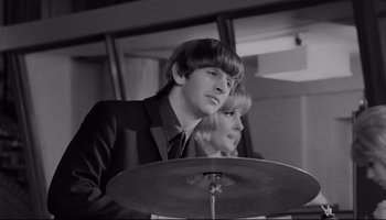 Movie still from “A Hard Day's Night” (1964), directed by Richard Lester – A man and a woman are playing drums together; Close Up shot, Over the shoulder angle