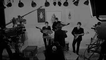 Movie still from “A Hard Day's Night” (1964), directed by Richard Lester – A black and white photo of the beatles playing in a studio; Wide shot, High angle