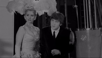 Movie still from “A Hard Day's Night” (1964), directed by Richard Lester – A man and a woman posing for a picture; Medium shot, Over the shoulder angle