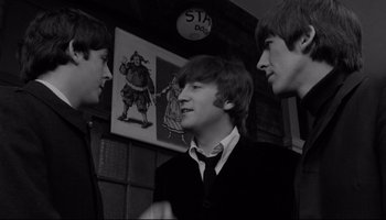 Movie still from “A Hard Day's Night” (1964), directed by Richard Lester – A group of young men standing next to each other in a room; Medium shot, Over the shoulder angle