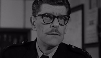 Movie still from “A Hard Day's Night” (1964), directed by Richard Lester – An older man wearing glasses and a military uniform; Close Up shot, Low angle