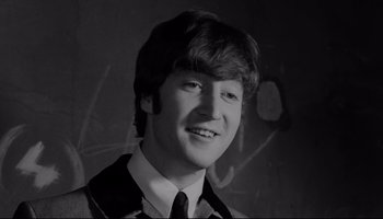Movie still from “A Hard Day's Night” (1964), directed by Richard Lester – A young man wearing a suit and tie smiling for the camera; Close Up shot, Low angle
