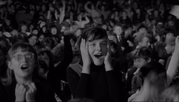 Movie still from “A Hard Day's Night” (1964), directed by Richard Lester – A young girl with her mouth wide open in front of a crowd; Medium shot, High angle