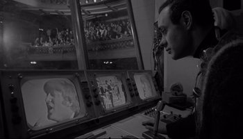 Movie still from “A Hard Day's Night” (1964), directed by Richard Lester – A man is looking at a television screen; Medium shot, Low angle