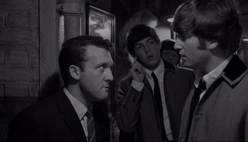 Movie still from “A Hard Day's Night” (1964), directed by Richard Lester – A group of young men standing next to each other; Medium shot, Over the shoulder angle