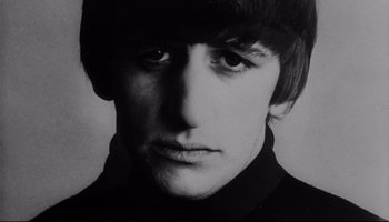 Movie still from “A Hard Day's Night” (1964), directed by Richard Lester – A person wearing a black shirt; Close Up shot, High angle