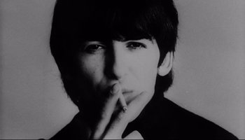 Movie still from “A Hard Day's Night” (1964), directed by Richard Lester – A black - and - white photo of a man smoking a cigarette; Close Up shot, High angle