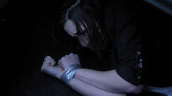 Movie still from “A Horrible Way to Die” (2010), directed by Adam Wingard – A woman with long black hair wearing a black shirt and a silver arm band; Close Up shot, High angle