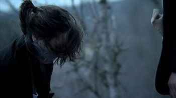 Movie still from “A Horrible Way to Die” (2010), directed by Adam Wingard – A person with long hair is standing in a room; Close Up shot, Low angle