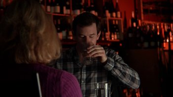Movie still from “A Horrible Way to Die” (2010), directed by Adam Wingard – A man drinking a glass of wine at a bar; Close Up shot, Over the shoulder angle