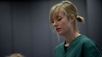 Movie still from “A Horrible Way to Die” (2010), directed by Adam Wingard – A woman in a green shirt is looking down; Close Up shot, Low angle