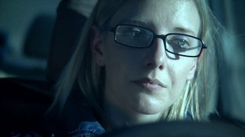 Movie still from “A Horrible Way to Die” (2010), directed by Adam Wingard – A woman wearing glasses sitting in a car; Extreme Close Up shot, Low angle