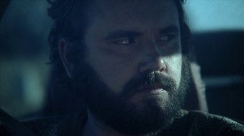 Movie still from “A Horrible Way to Die” (2010), directed by Adam Wingard – A man with long hair and a goatee; Close Up shot, Low angle