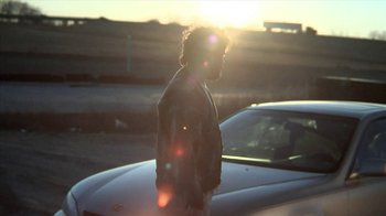 Movie still from “A Horrible Way to Die” (2010), directed by Adam Wingard – A man standing next to a car on the side of the road; Wide shot, Low angle