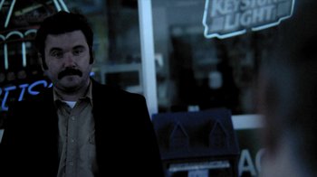 Movie still from “A Horrible Way to Die” (2010), directed by Adam Wingard – A man standing in front of a store window at night; Medium shot, Low angle