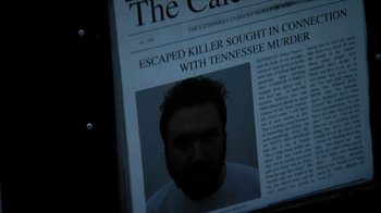 Movie still from “A Horrible Way to Die” (2010), directed by Adam Wingard – A man with a beard is in front of a news paper; Extreme Close Up shot, Overhead angle
