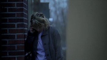 Movie still from “A Horrible Way to Die” (2010), directed by Adam Wingard – A woman is standing in the rain talking on a phone; Medium shot, Low angle