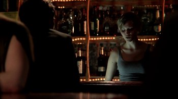 Movie still from “A Horrible Way to Die” (2010), directed by Adam Wingard – A woman sitting in front of a mirror in front of a bar; Medium shot, Low angle