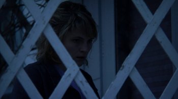 Movie still from “A Horrible Way to Die” (2010), directed by Adam Wingard – A woman standing in front of a white fence; Close Up shot, Low angle