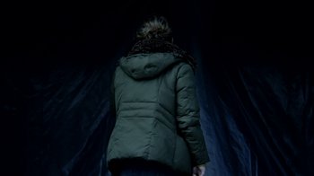 Movie still from “A Horrible Way to Die” (2010), directed by Adam Wingard – A woman wearing a green jacket standing in the dark; Medium shot, Low angle