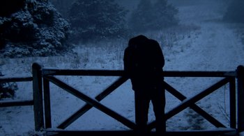 Movie still from “A Horrible Way to Die” (2010), directed by Adam Wingard – A man standing in the snow next to a fence; Wide shot, Low angle