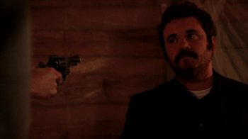Movie still from “A Horrible Way to Die” (2010), directed by Adam Wingard – A man holding a gun in front of him; Close Up shot, Over the shoulder angle