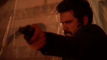 Movie still from “A Horrible Way to Die” (2010), directed by Adam Wingard – A man holding a gun in a room; Close Up shot, Low angle