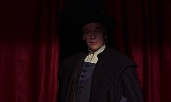 Movie still from “A Man for All Seasons” (1966), directed by Fred Zinnemann – A man wearing a black hat and a black coat; Medium shot, Low angle