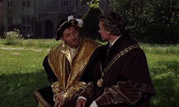 Movie still from “A Man for All Seasons” (1966), directed by Fred Zinnemann – Two men dressed in medieval clothing sitting on a bench; Medium shot, Over the shoulder angle