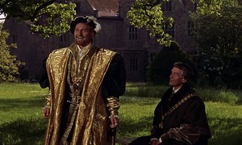 Movie still from “A Man for All Seasons” (1966), directed by Fred Zinnemann – Two men dressed in medieval garb in front of a building; Medium shot, Over the shoulder angle