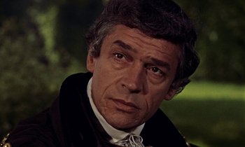 Movie still from “A Man for All Seasons” (1966), directed by Fred Zinnemann – An older man wearing a black coat and a bow tie; Close Up shot, Low angle