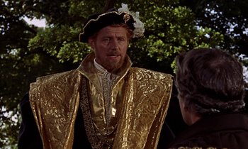 Movie still from “A Man for All Seasons” (1966), directed by Fred Zinnemann – A man in a gold outfit talking to another man; Medium shot, Over the shoulder angle