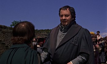 Movie still from “A Man for All Seasons” (1966), directed by Fred Zinnemann – A man and a woman are standing in front of a hill; Medium shot, Over the shoulder angle