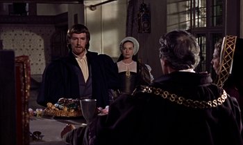 Movie still from “A Man for All Seasons” (1966), directed by Fred Zinnemann – A man and a woman are standing in front of a woman; Medium shot, Over the shoulder angle