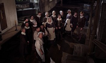 Movie still from “A Man for All Seasons” (1966), directed by Fred Zinnemann – A group of people dressed as nuns standing in front of a staircase; Wide shot, High angle