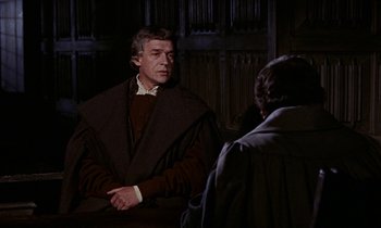 Movie still from “A Man for All Seasons” (1966), directed by Fred Zinnemann – A man wearing a brown robe and a white shirt is talking to another man; Medium shot, Over the shoulder angle