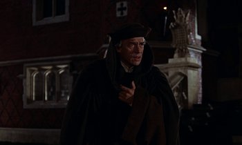 Movie still from “A Man for All Seasons” (1966), directed by Fred Zinnemann – A man wearing a black robe and a hat; Medium shot, Over the shoulder angle