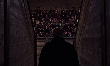 Movie still from “A Man for All Seasons” (1966), directed by Fred Zinnemann – A crowd of people watching a man in a black cape; Wide shot, High angle