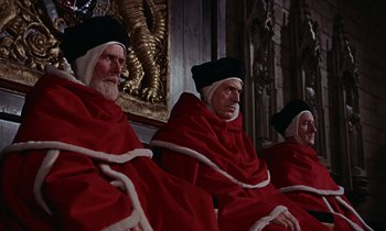 Movie still from “A Man for All Seasons” (1966), directed by Fred Zinnemann – A group of men sitting next to each other wearing robes; Medium shot, High angle