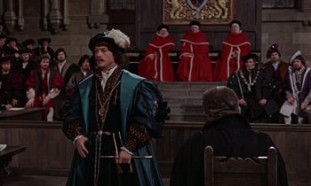 Movie still from “A Man for All Seasons” (1966), directed by Fred Zinnemann – A man dressed in medieval clothing stands in front of a group of people; Medium shot, Over the shoulder angle