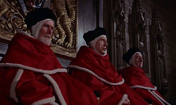 Movie still from “A Man for All Seasons” (1966), directed by Fred Zinnemann – A group of people dressed in red robes and black hats; Medium shot, High angle