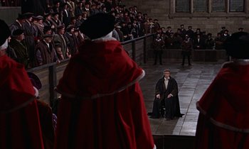 Movie still from “A Man for All Seasons” (1966), directed by Fred Zinnemann – A crowd of people watching a man sit on a chair; Wide shot, High angle